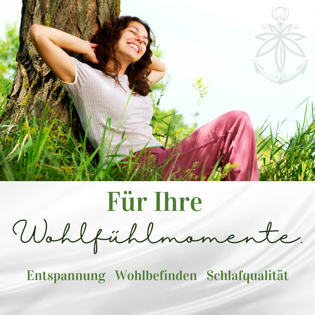 Frau lehnt entspannt gegen Baum im Gras, sonniger Tag, grüne Natur, Text „Für Ihre Wohlfühlmomente“.