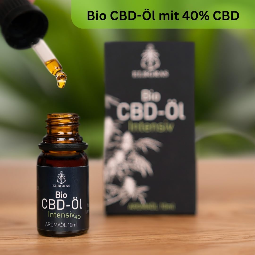Braune Glasflasche Elbgras Bio-CBD-Öl 40% mit Pipette und schwarzem Etikett, Verpackung im Hintergrund.